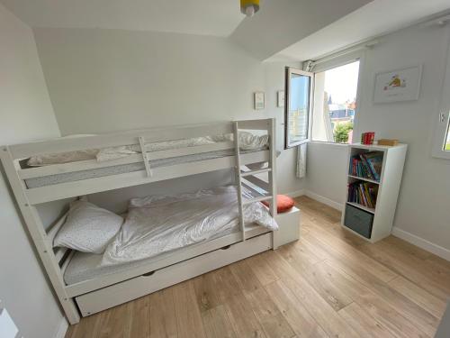 une chambre avec deux lits superposés et une fenêtre dans l'établissement La Marée ZéLée - appartement à 50 mètres de la mer, à Wimereux