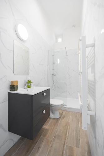 une salle de bain blanche avec un lavabo et des toilettes dans l'établissement Le Concorde 2 - Appartement 1 chambre Clim Calanques Vélodrome, à Marseille