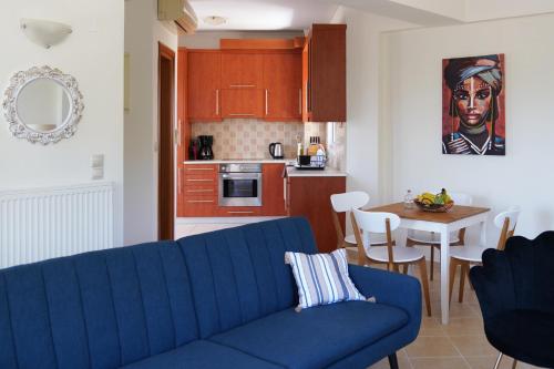Il comprend un salon avec un canapé bleu et une cuisine. dans l'établissement Hestia Maisonette, à Arónion