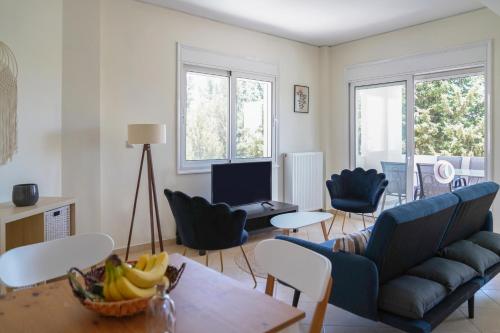uma sala de estar com um sofá, cadeiras e uma mesa em Hestia Maisonette em Arónion