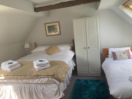 a bedroom with two beds with towels on them at The Lampet Arms in Banbury