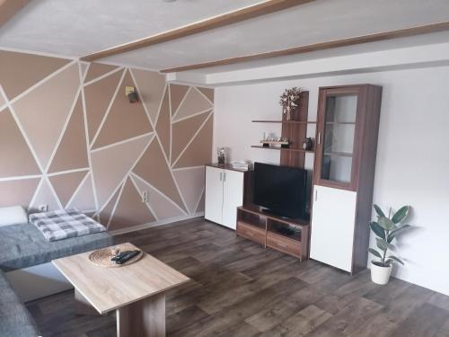 ein Wohnzimmer mit einem Sofa und einem TV in der Unterkunft Ferienwohnung Kilian in Weberstedt