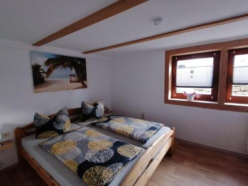 ein Schlafzimmer mit einem Bett und zwei Fenstern in der Unterkunft Ferienwohnung Kilian in Weberstedt