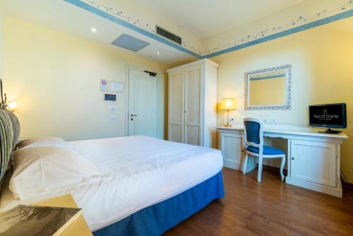 a bedroom with a bed and a desk and a computer at Hotel Borgo Di Cortefreda - Place of Charme in Tavarnelle in Val di Pesa