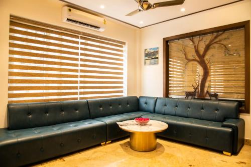 a living room with a blue couch and a table at Hotel Dream Inn in Rishīkesh
