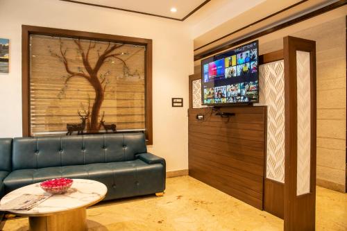 a living room with a couch and a table and a television at Hotel Dream Inn in Rishīkesh
