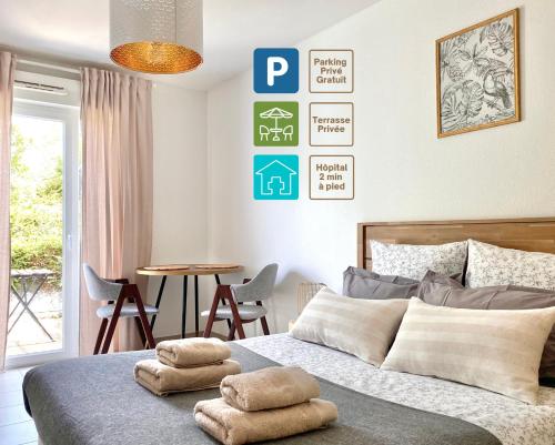 a bedroom with a bed with two towels on it at Studio en face Hopital Nord avec terrasse in Saint-Priest-en-Jarez