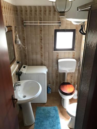 a small bathroom with a toilet and a sink at Villaggio Bianco in San Giacomo