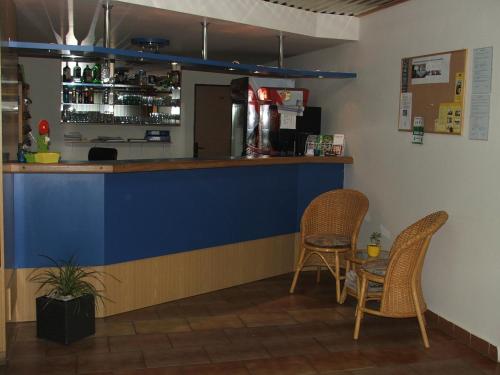 a bar with two chairs and a counter at Hotel Sport in Jablonec nad Nisou