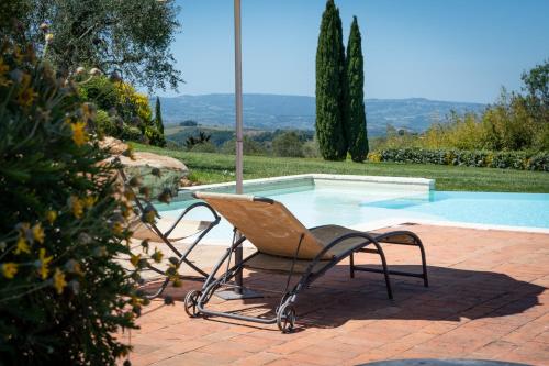 a chair sitting next to a swimming pool at Hotel Borgo Di Cortefreda - Place of Charme in Tavarnelle in Val di Pesa