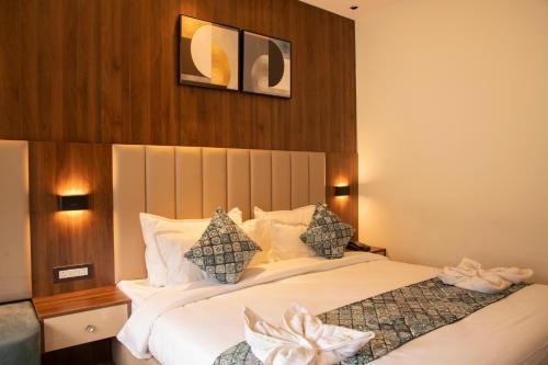 a bedroom with a large bed with white sheets at Hotel Dream Inn in Rishīkesh
