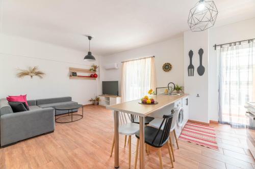 Il comprend une cuisine et un salon avec une table et un canapé. dans l'établissement Modern Escape Near Riviera & Niarchos Foundation!, à Athènes