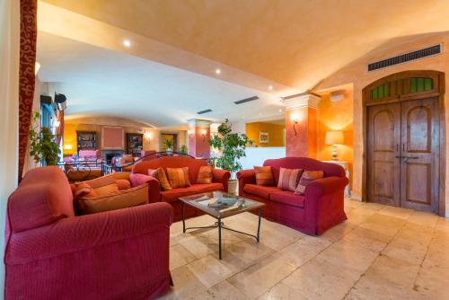 a living room with two red couches and a table at Hotel Borgo Di Cortefreda - Place of Charme in Tavarnelle in Val di Pesa