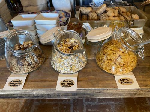 a display of different types of food in jars on a table at Ex Convento Santa Croce-Country resort in SantʼAnatolia di Narco