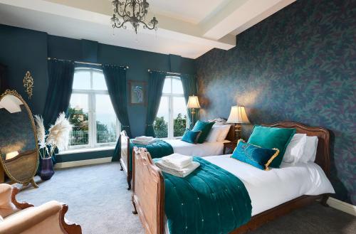 two beds in a room with blue walls at The Spa Chalet Scarborough Hot tub, pool, gym, beach location in Scarborough