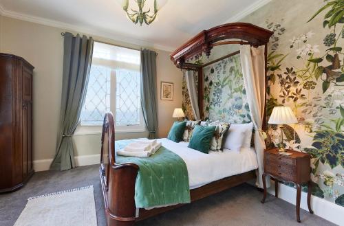 a bedroom with a canopy bed and a window at The Spa Chalet Scarborough Hot tub, pool, gym, beach location in Scarborough