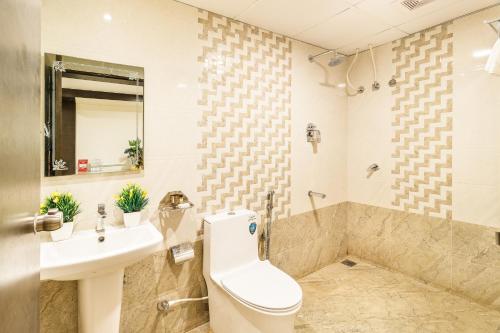 a bathroom with a toilet and a sink and a tub at Octave Nest Inn in Bengaluru