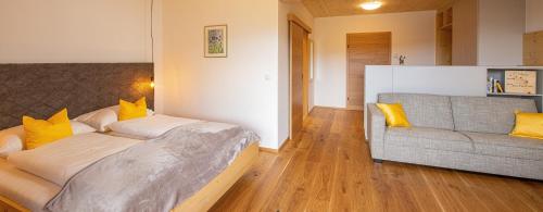 a bedroom with a bed and a couch at Pircherhof - Adults Only am Biobauernhof in Pöllau