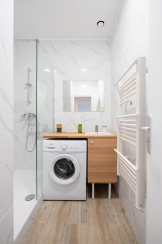 une salle de bain blanche avec une machine à laver à l'intérieur dans l'établissement Le Concorde 3 - Appartement 2 chambres - 8 pers - Terrasse - Clim, à Marseille