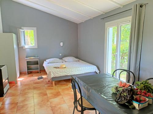 une pièce avec une table et un lit et une table et des chaises dans l'établissement Domaine Le Moulin Neuf, à Saint-Quentin-la-Poterie