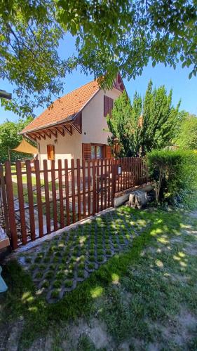 a wooden fence in front of a house at Relax II. Vendégház in Dunapataj