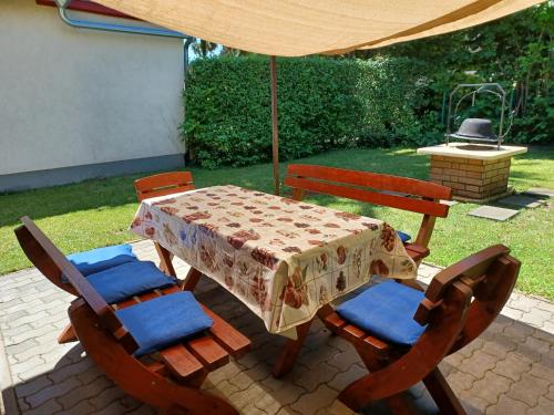 a table and chairs with a table and an umbrella at Relax II. Vendégház in Dunapataj