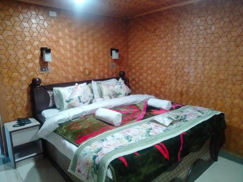 a bedroom with a bed in a room at Hotel Mughal India in Sonāmarg