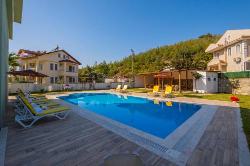 una piscina en una villa con una casa en Infinity Lily Apartments en Fethiye