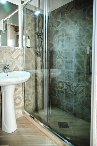 a bathroom with a glass shower and a sink at Mercede Rooms in Palermo