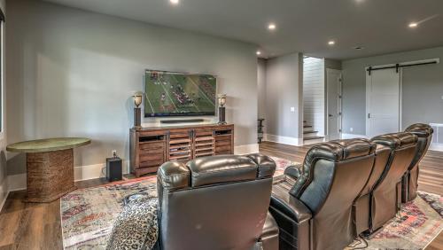 a living room with two leather chairs and a flat screen tv at Bunker Down in Mineral Bluff