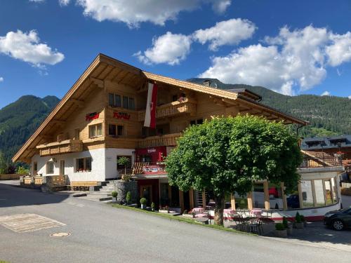 a large building with a tree in front of it at Aparthotel Tyrol in Lermoos