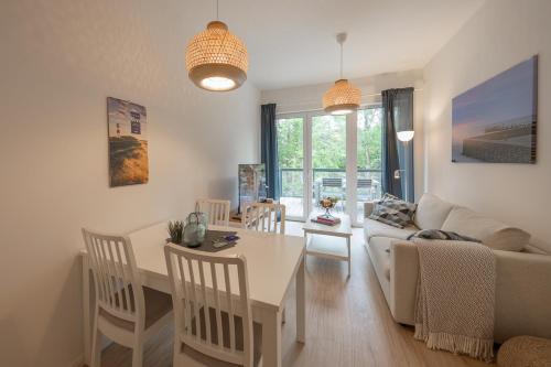 ein Wohnzimmer mit einem Tisch und einem Sofa in der Unterkunft Wohnen am Südstrand - Ferienwohnung 1 5 in Wyk auf Föhr