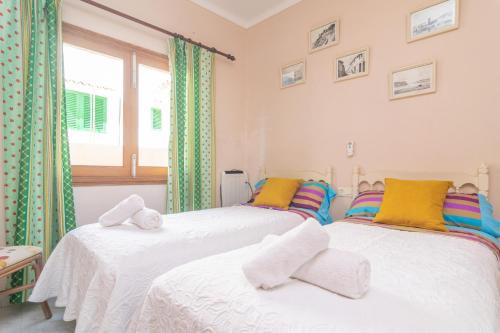 two twin beds in a room with a window at Ca na Clar in Sa Ràpita