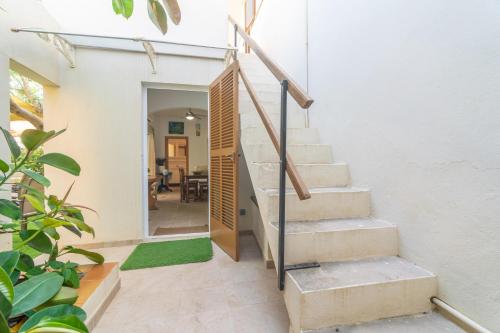 a staircase in a house with a green rug at Ca na Clar in Sa Ràpita