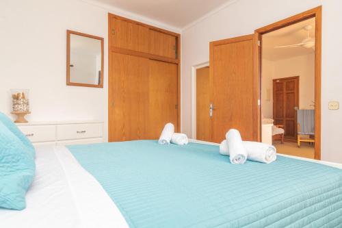 a bedroom with a blue bed with towels on it at Ca na Clar in Sa Ràpita