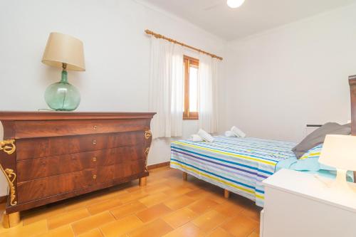 a bedroom with a bed and a dresser and a window at Ca na Clar in Sa Ràpita