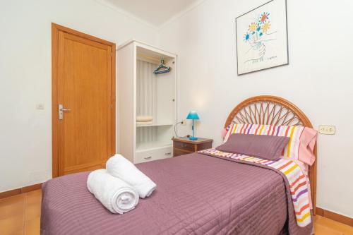 a bedroom with a purple bed and a wooden door at Ca na Clar in Sa Ràpita
