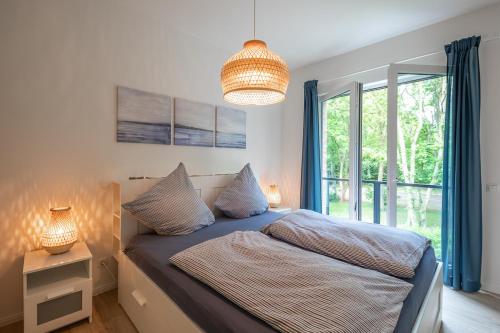 ein Schlafzimmer mit einem Bett und einem großen Fenster in der Unterkunft Wohnen am Südstrand - Ferienwohnung 1 7 in Wyk auf Föhr