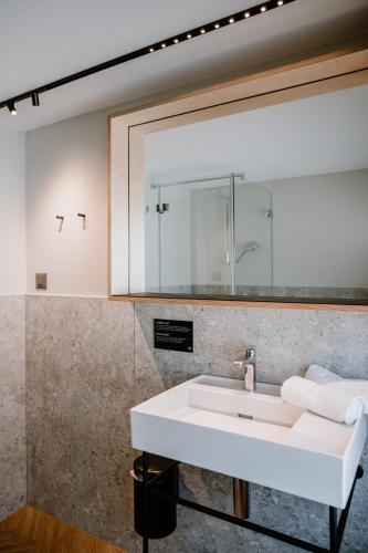 a bathroom with a sink and a mirror at Hotel Müllers Self-Check-In in Arbon