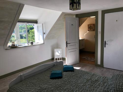 a bedroom with a bed with blue pillows and a window at La Dernière Étape in Port-Launay