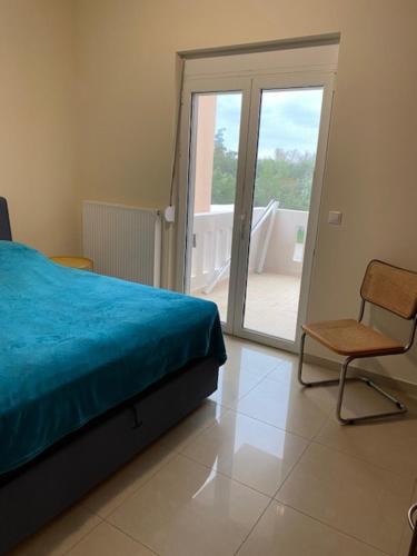 a bedroom with a bed and a chair and a balcony at Comfortable and Modern Holiday Apartment - Alex Apartment II in Daratso