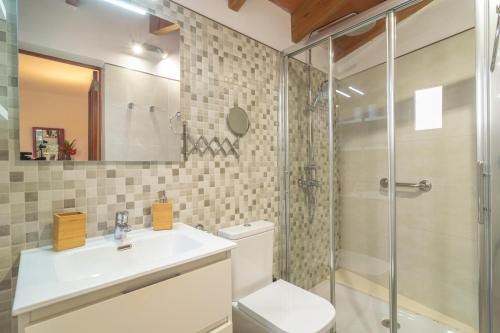 Un baño con inodoro, lavabo y ducha. en Sa Fornera, en Alcudia