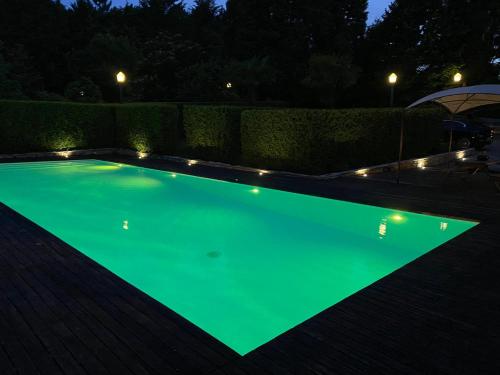 a swimming pool with green illumination at night at Villas do Monte in Guimarães