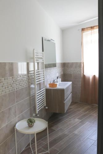 a bathroom with a sink and a mirror and a table at Maison Matilda in Capo dʼOrlando