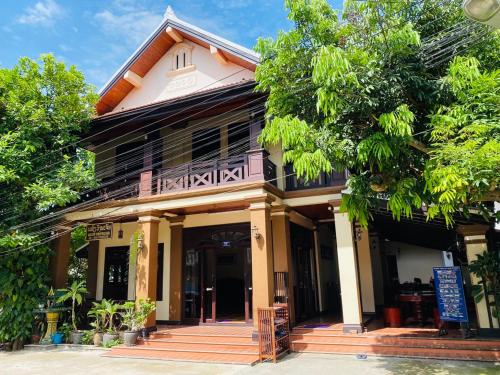 a house with a balcony on top of it at Luang Prabang Maison Vongprachan & Travel in Luang Prabang