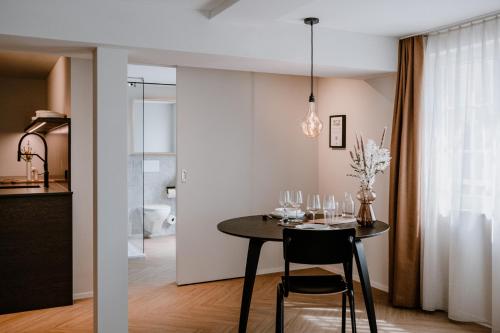 a dining room and kitchen with a table and chairs at Hotel Müllers Self-Check-In in Arbon
