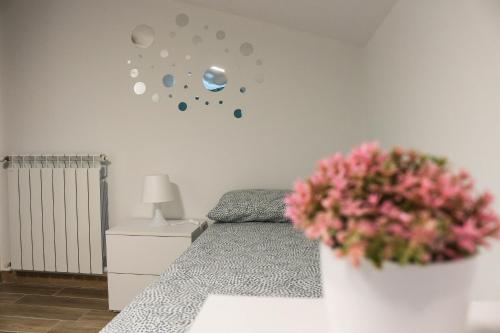 a bedroom with a bed and a vase with pink flowers at Maison Matilda in Capo dʼOrlando