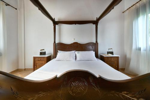 um quarto com uma cama grande e uma estrutura em madeira em Villa Elia by PosarelliVillas em Vryses