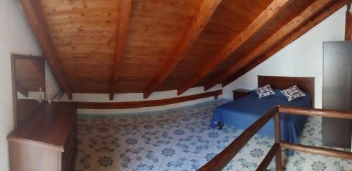 a bedroom with a blue bed and a wooden ceiling at Little House Forio in Forio d'Ischia