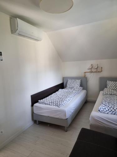 two beds in a room with white walls at Dwie Mewy in Pobierowo